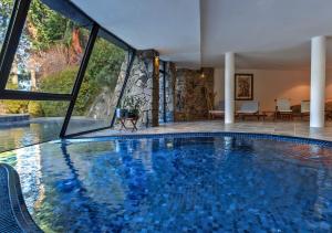 a large swimming pool in a building with a large window at Costa Serena Aparts & Spa in Villa La Angostura