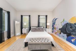 a bedroom with a bed and a painting on the wall at Queen City's Den Uptown in Charlotte