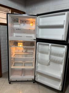 an empty refrigerator with its door open in a kitchen at Casa Refugio natural in Puerto Triunfo