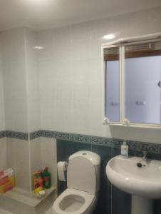 a bathroom with a toilet and a sink at Piso Ría de Ribadeo in Ribadeo