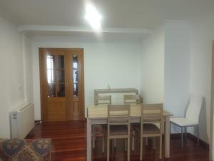 a dining room with a table and chairs and a door at Piso Ría de Ribadeo in Ribadeo +9 photos