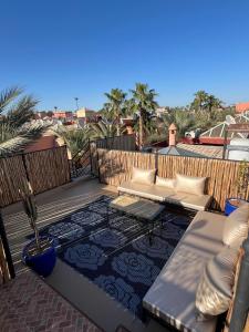 a patio with a couch and a table on a roof at RIAD Al QARYA 4 chambres in Marrakech