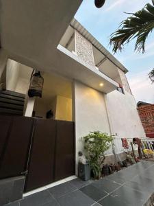 une grande maison blanche avec un porche et une plante dans l'établissement Pasuruan heritage guest house, 