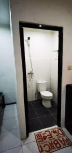 une salle de bain avec toilettes et douche dans l'établissement Pasuruan heritage guest house, 