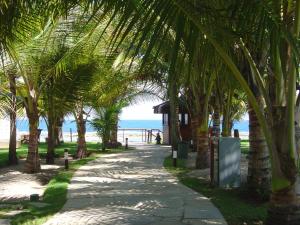 un sendero bordeado de palmeras junto a la playa en Nannai Residence, en Porto de Galinhas