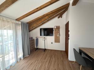 a living room with wooden ceilings and a flat screen tv at Къща за гости Сирената in Sozopol