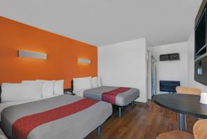 una camera d'albergo con due letti e un tavolo di Motel 6 San Jose CA South a San Jose Altre 15 foto