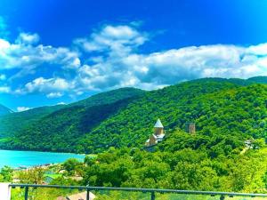 a view of a hill with a church and a lake at Berg Ananuri in Ananuri