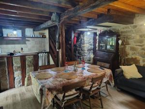 a dining room with a table with chairs and a couch at Cabaña Pasiega "La Reina del Paraíso" in San Roque de Ríomiera