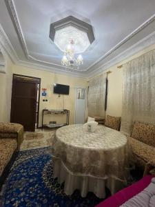 Una sala de estar con una mesa y una lámpara de araña. en Dar RACHIDA RIFIYA Estudio privado, en Tánger