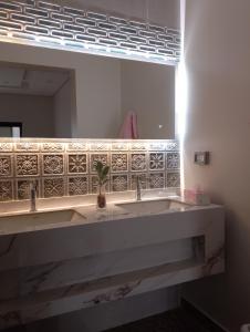 Ma‘ābīlahにあるفيلا VillAの洗面台が2つと大きな鏡があるバスルーム