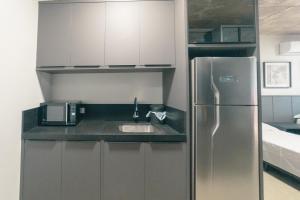 マリンガにあるEstilo e Praticidade no Centro - CA1505のステンレス製の冷蔵庫とシンクを備えたキッチン