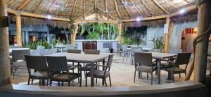 a restaurant with tables and chairs and a roof at Casa Condo Diamante, Nueva Vallarta in Nuevo Vallarta