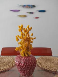 a red vase with flowers in it on a table at The cozy seaside apartment in Nafpaktos