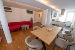a living room with a table and a red couch at "Ferienhaus Wonderland in Coburg" - mit Terasse und Parking in Coburg