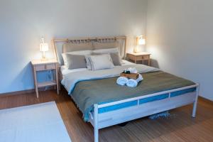 een slaapkamer met een groot bed met twee nachtkastjes bij Beachfront Costa Nova Villa - 2BR Apartment in Gafanha da Encarnação