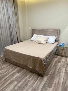 a bed in a bedroom with a wooden floor at Medinaty in Madinaty