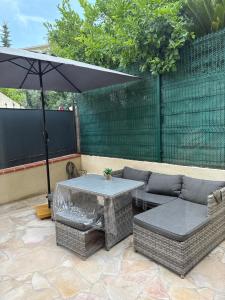 un patio con mesa, sofá y sombrilla en CANNES Maison Design "DOLCE VITA", en Cannes