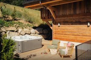 Un jacuzzi en una terraza junto a un edificio. en Chalet Galata - OVO Network, en Combloux