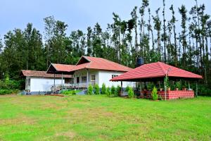 a house with a red roof in a yard at Siri Kuteera Homestay in Vastāra
