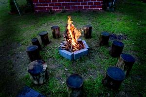 a fire pit in a yard with logs around it at Siri Kuteera Homestay in Vastāra