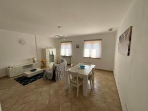 a living room with a white table and chairs at BB Controtempo in Montesano Scalo