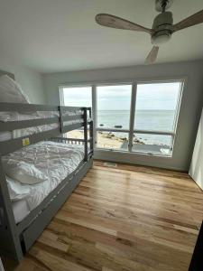a bedroom with a bunk bed and a view of the ocean at Beachfront Greenport Villa in Greenport