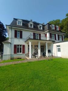 a large white house with a large yard at Die Villa Hotel in Leverkusen