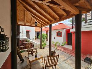 a patio with chairs and a table and a wooden roof at Casa de Zari in Campeche