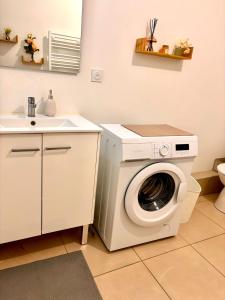 a washing machine in a kitchen with a sink at Cosy T2 neuf avec balcon Proche centre & plage in Montpellier