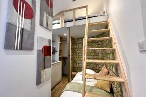 a room with a bunk bed with a ladder at La petite maisonnette de la gare in Nancy