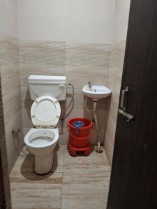 a bathroom with a toilet and a sink at Hotel Kanhaiya Inn in Haridwār