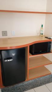 a microwave oven sitting inside of a wooden cabinet at Flat confortável e completo a 800m do Hot Park in Rio Quente