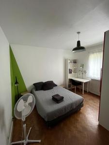 een slaapkamer met een bed, een stoel en een tafel bij Maison avec piscine près de Bordeaux in Bègles +9 foto's