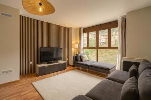 a living room with a couch and a flat screen tv at 1692m Valdelinares in Valdelinares