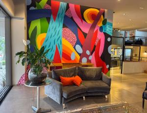 - un salon avec un canapé et un mur coloré dans l'établissement Coral Trade e Eventos prox a Pucrs, Araujo Vianna, à Porto Alegre