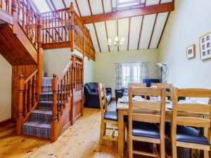 a dining room and living room with a table and stairs at Beudy - Uk31388 in Caeathro