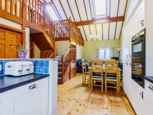 a kitchen with a table and a dining room at Beudy - Uk31388 in Caeathro