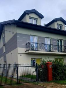 a house with two balconies and a fence at Pensjonat u Ewy in Głowno
