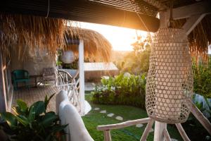 a porch of a house with a rattan hanging basket at Gravity Eco Boutique Hotel - Adults Only in Uluwatu
