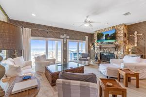 a living room with white furniture and a stone wall at Blue Angel, Blue Angel -Gulf Front, Beautiful Views! Great for Families! in Pensacola Beach