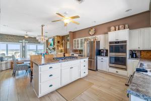 a kitchen with white cabinets and a ceiling fan at Blue Angel, Blue Angel -Gulf Front, Beautiful Views! Great for Families! in Pensacola Beach +28 photos