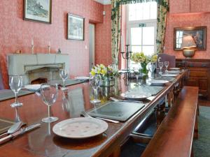 a long table with plates and wine glasses on it at Crogen Coach House - Oqr in Llandrillo +30 photos