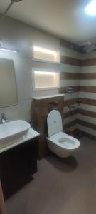 a bathroom with a white toilet and a sink at Sai prabha in Ernakulam