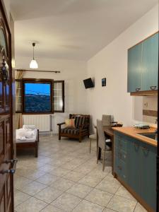 a kitchen and living room with a table and chairs at Cerigo House in Kondoliánika