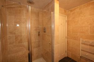 La salle de bains est pourvue d'une douche avec une porte en verre. dans l'établissement Central Studios Gloucester Road by RoomsBooked - Free Parking, à Cheltenham