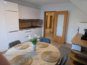 a dining room table with two chairs and a kitchen at Bauers Ferienwohnung in Wabern