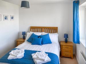 a bedroom with a blue and white bed with blue pillows at Blissful Ocean Breeze in Perranporth