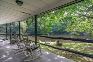 two chairs on a porch with a view of a river at Mill House Nest in Flat Rock