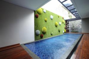 a swimming pool in a room with a rock wall at Dago Teuku Angkasa 14 in Bandung
